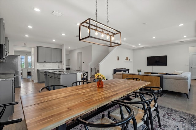 dining space featuring sink and light tile patterned flooring