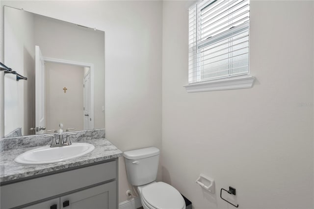 bathroom with toilet, plenty of natural light, and vanity