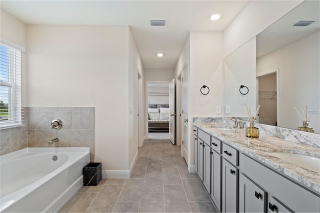 bathroom featuring vanity, a bathtub, and tile patterned floors