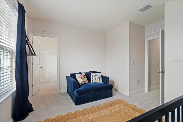 bedroom with light colored carpet and a spacious closet