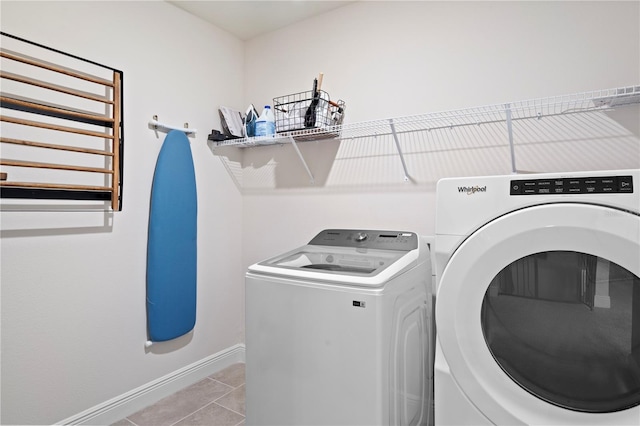 laundry room featuring washer and dryer, radiator heating unit, and light tile patterned flooring