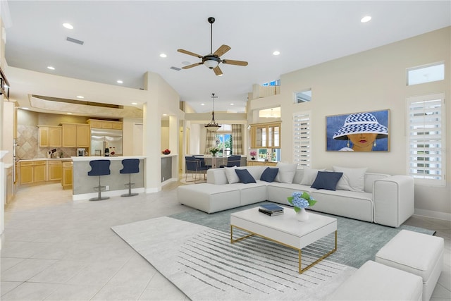 living room featuring ceiling fan, a wealth of natural light, and light tile patterned flooring