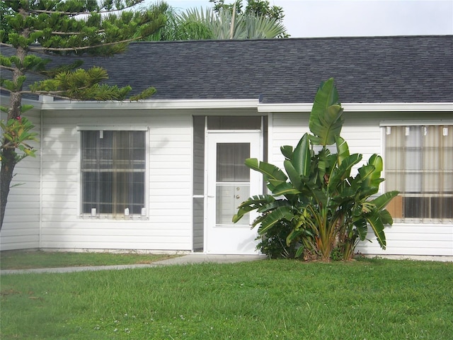 entrance to property with a lawn