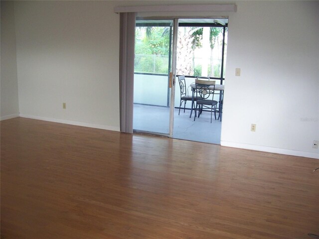 empty room with dark hardwood / wood-style flooring