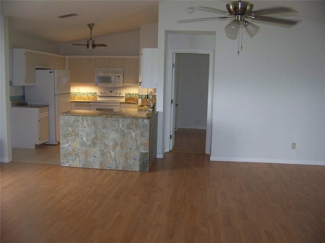 kitchen featuring white appliances, wood-type flooring, ceiling fan, lofted ceiling, and white cabinets