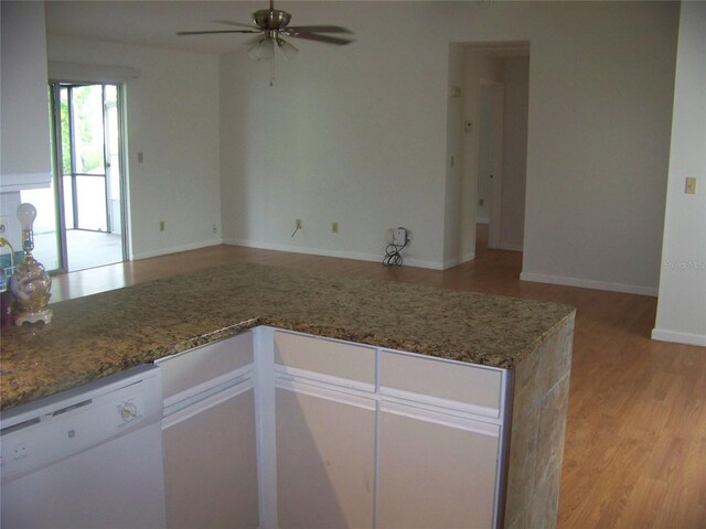 kitchen with dishwasher, ceiling fan, light wood-type flooring, and dark stone counters