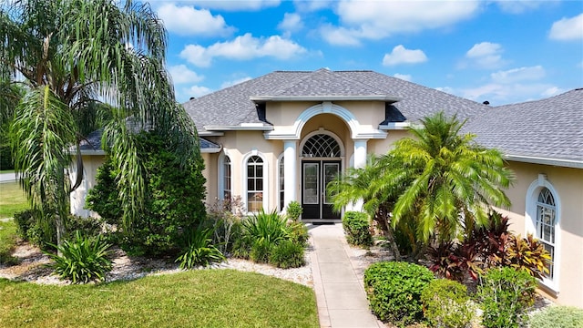 mediterranean / spanish house with french doors and a front lawn