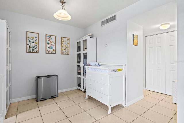 kitchen with decorative light fixtures, white cabinets, and light tile patterned floors