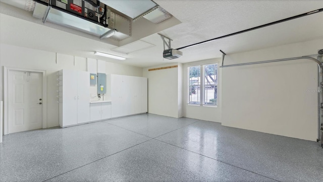 garage with a garage door opener and electric panel