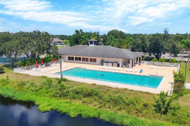 view of pool with a water view and a patio area