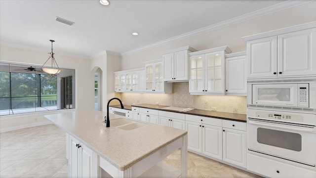 kitchen featuring white appliances, sink, white cabinetry, pendant lighting, and crown molding