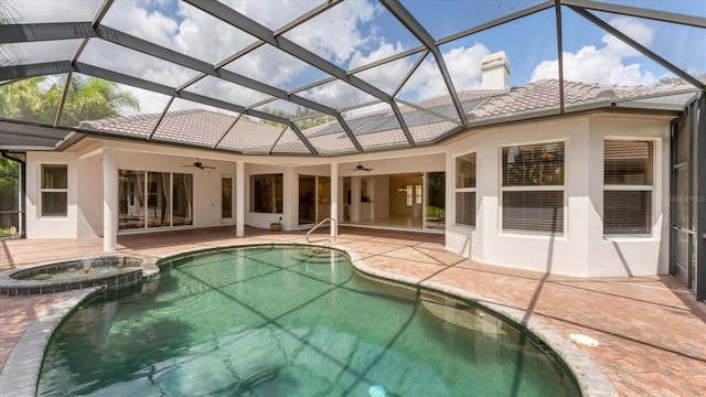 view of swimming pool with an in ground hot tub, ceiling fan, glass enclosure, and a patio area