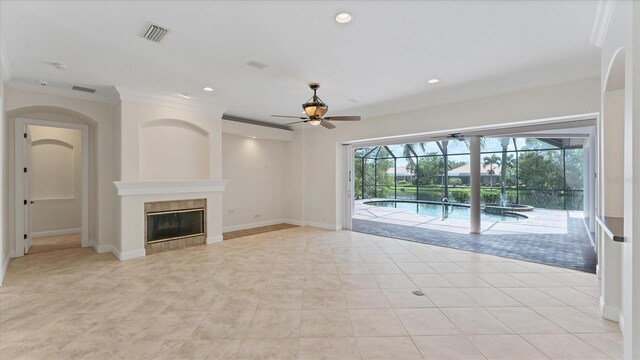 unfurnished living room featuring ornamental molding, a fireplace, light tile patterned floors, and ceiling fan