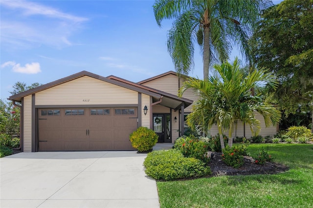 single story home featuring a front lawn and a garage