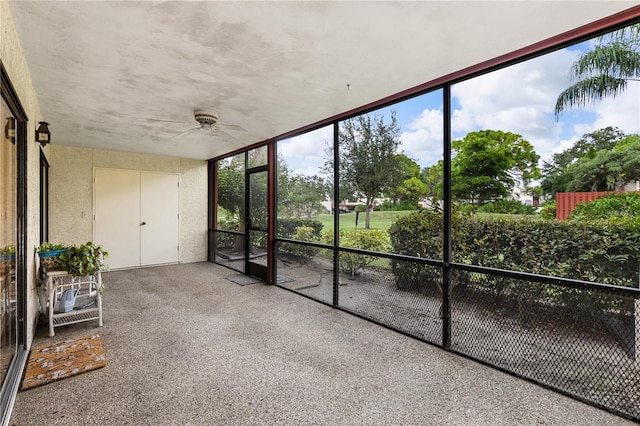 unfurnished sunroom featuring ceiling fan