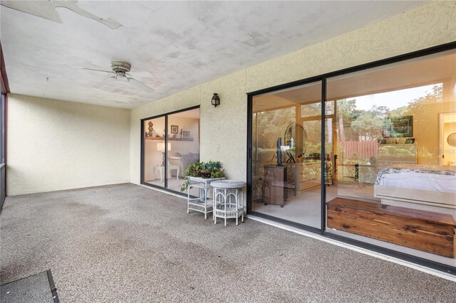 unfurnished sunroom with ceiling fan