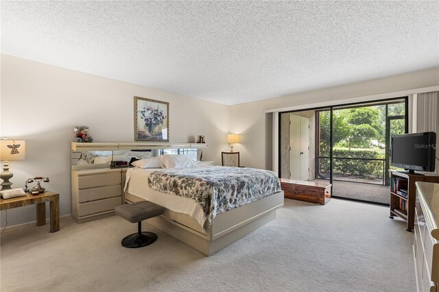 carpeted bedroom featuring a textured ceiling and access to outside