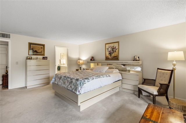 bedroom with light carpet and a textured ceiling