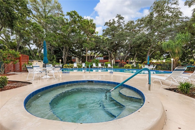 view of swimming pool with a hot tub and a patio