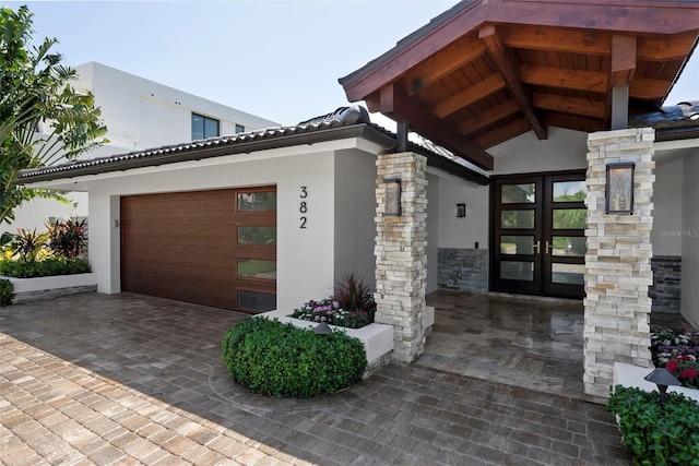 property entrance with a garage and french doors