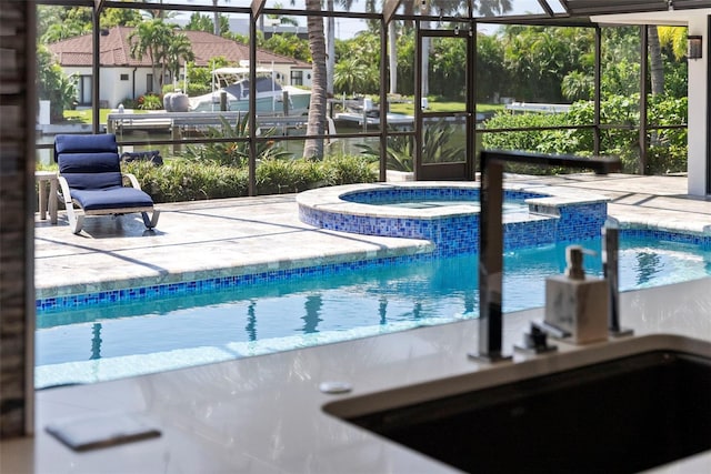 view of pool featuring a patio, an in ground hot tub, and a lanai