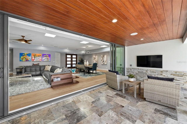 living room featuring ceiling fan and wood ceiling