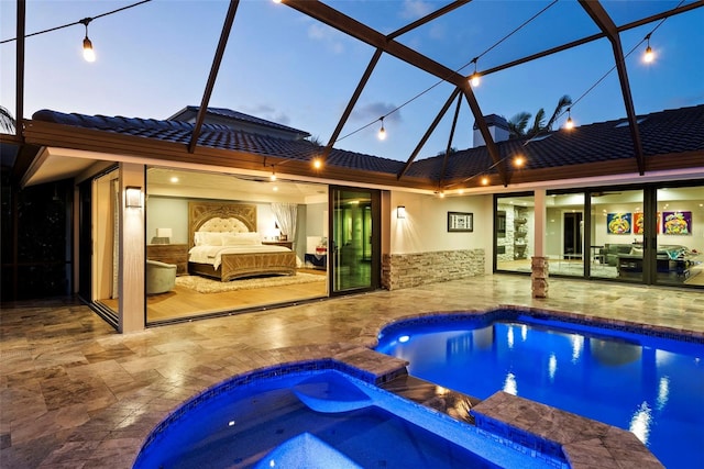 pool at dusk with glass enclosure, an in ground hot tub, an outdoor living space, and a patio area