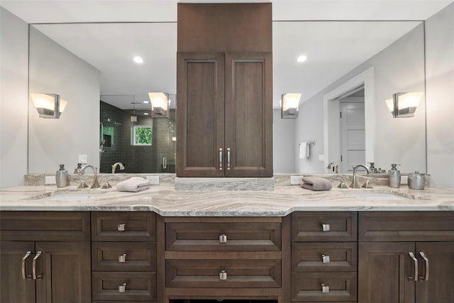 bathroom featuring a shower with door and vanity