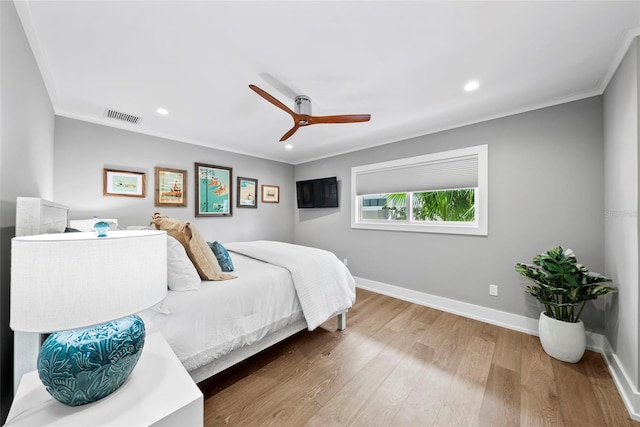 bedroom with ornamental molding, ceiling fan, and hardwood / wood-style flooring