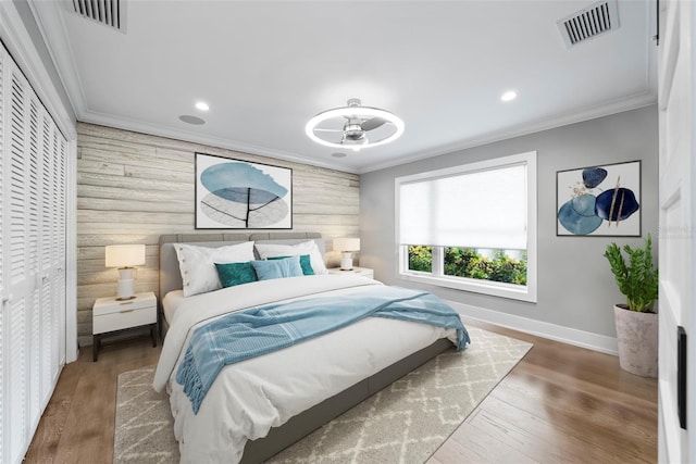 bedroom with wood walls, crown molding, and dark hardwood / wood-style flooring