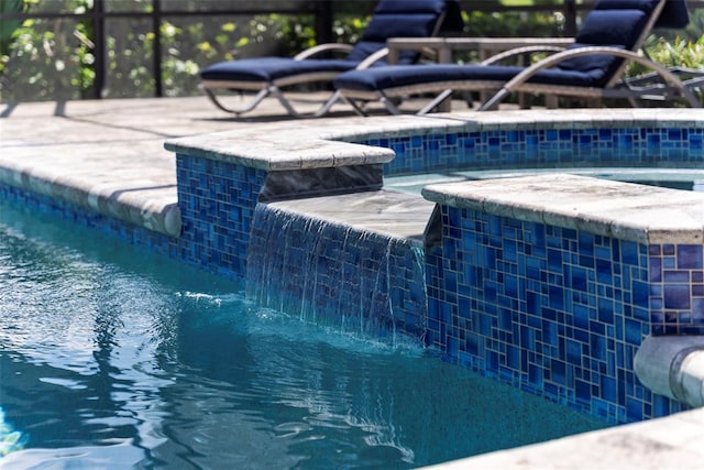 view of swimming pool with pool water feature