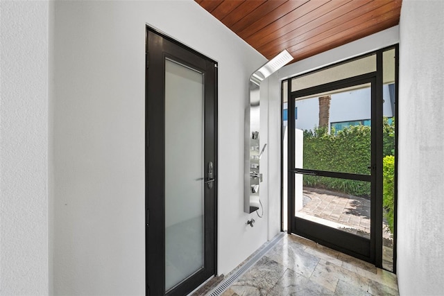 doorway to outside with wood ceiling