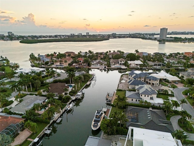 aerial view at dusk featuring a water view