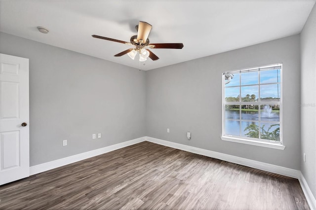 spare room featuring dark wood-type flooring and ceiling fan