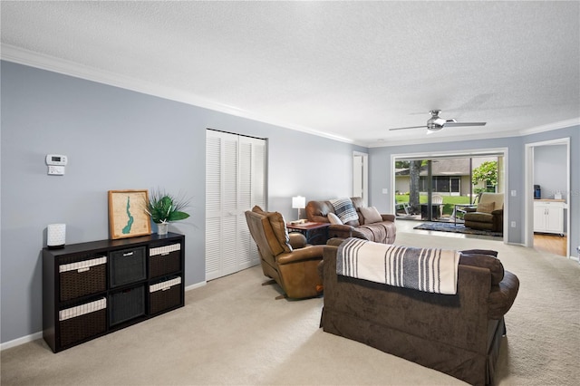 living room with a textured ceiling, light colored carpet, ceiling fan, and ornamental molding