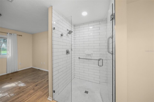 bathroom featuring a shower with door and hardwood / wood-style floors