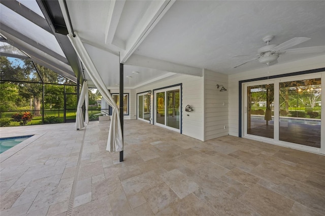 unfurnished sunroom featuring beamed ceiling, ceiling fan, and plenty of natural light