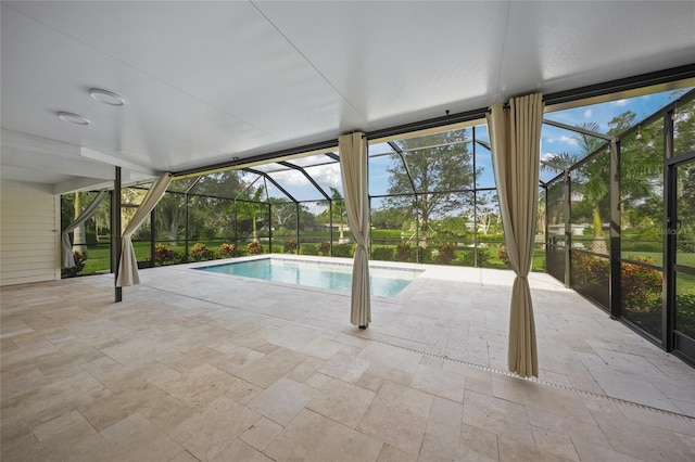 view of pool with glass enclosure and a patio area