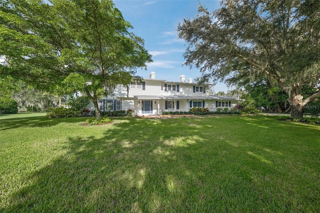 rear view of house featuring a yard