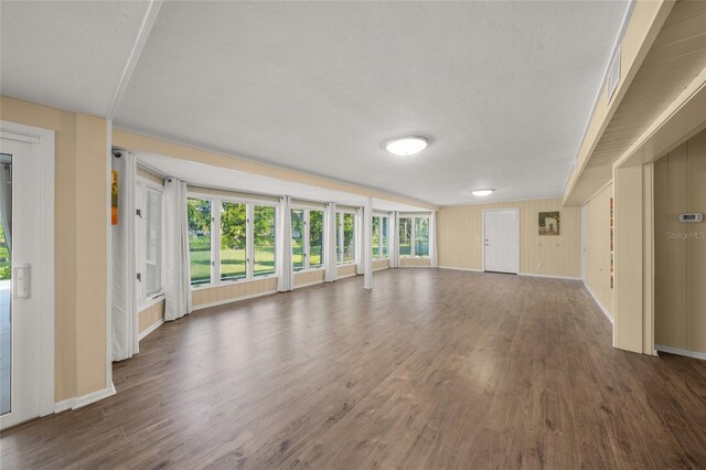 unfurnished living room with a textured ceiling and dark hardwood / wood-style floors