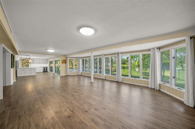 unfurnished living room featuring a textured ceiling and dark hardwood / wood-style flooring