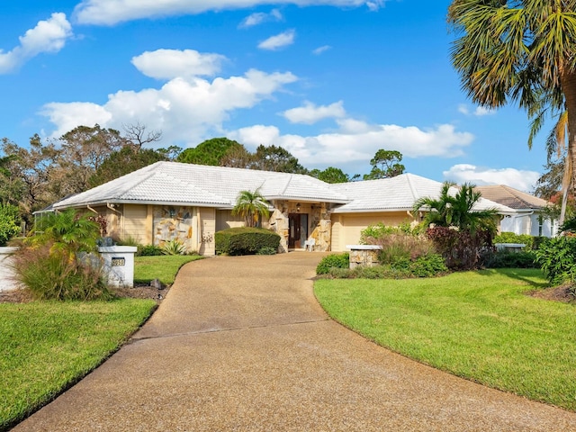 ranch-style home featuring a front lawn