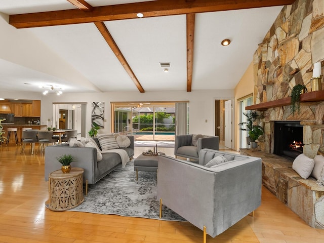 living room featuring high vaulted ceiling, light wood-type flooring, and a fireplace