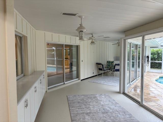 unfurnished sunroom featuring ceiling fan