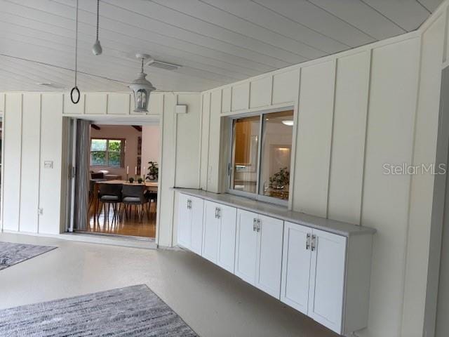 interior space with decorative light fixtures, white cabinetry, and wood ceiling