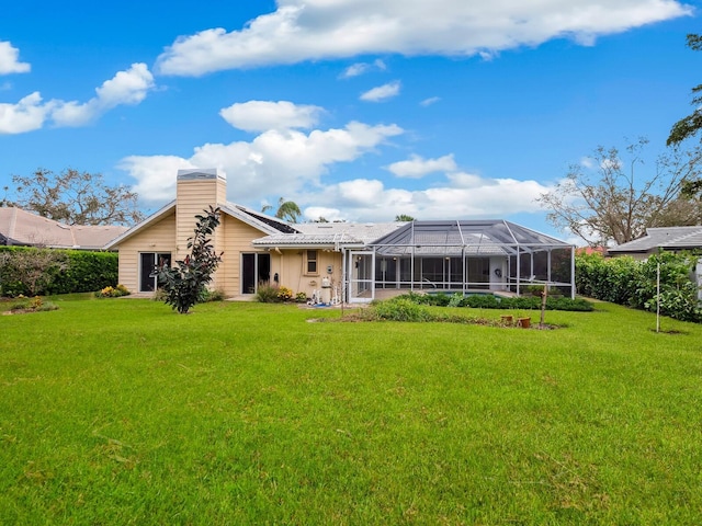 rear view of property featuring a lanai and a yard