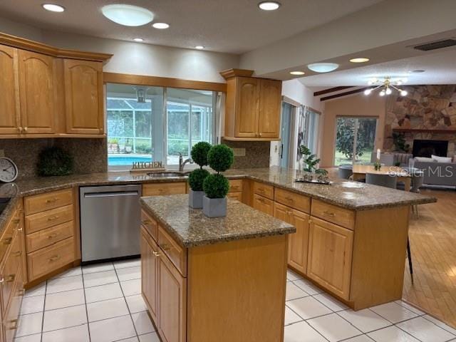 kitchen featuring dishwasher, a kitchen island, light tile patterned floors, and tasteful backsplash