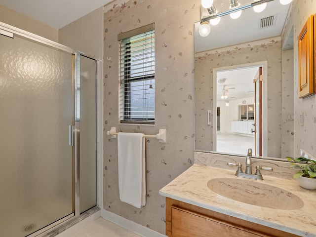 bathroom with a shower with door and vanity