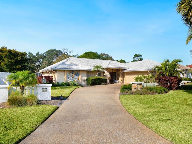 ranch-style home with a garage and a front yard