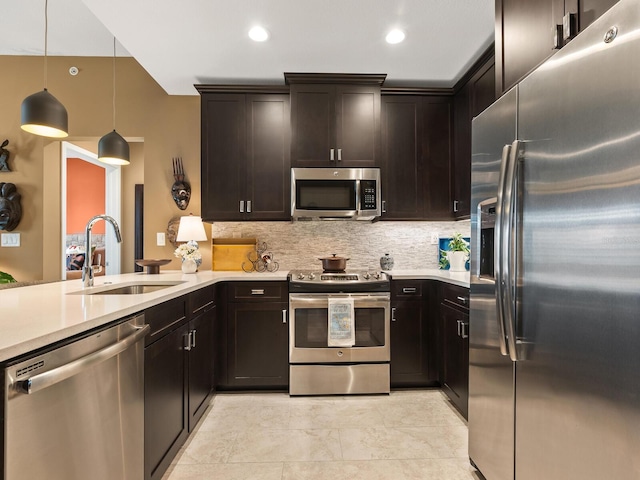 kitchen featuring sink, decorative light fixtures, appliances with stainless steel finishes, and dark brown cabinets